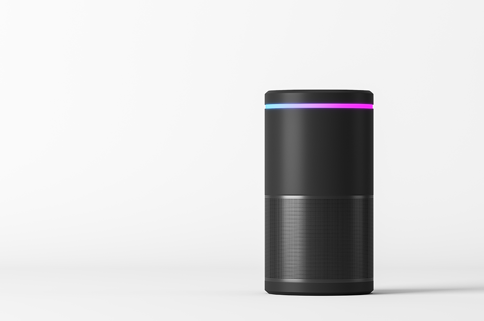 A cylindrical, black smart speaker against a white background.