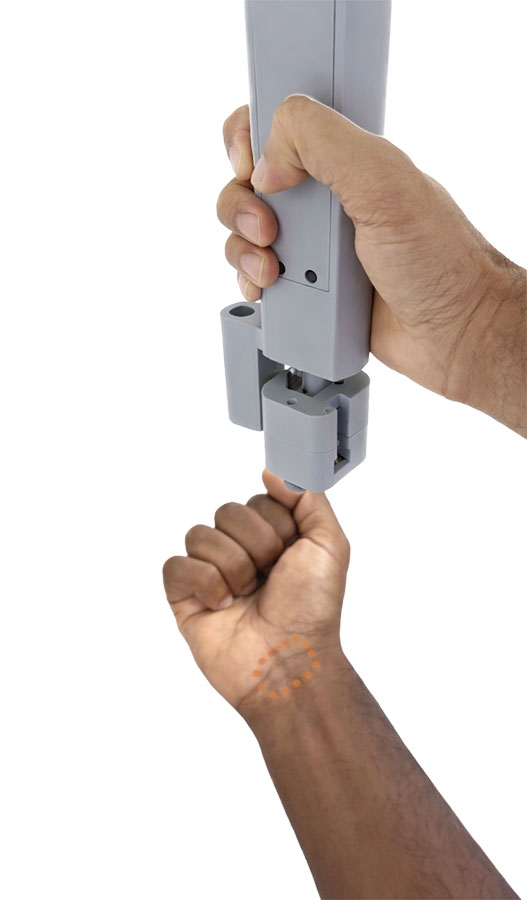  A hand points a large gray sensor at a wrist.