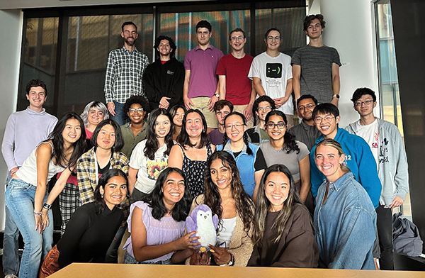  A group of students pose with a stuffed purple penguin.