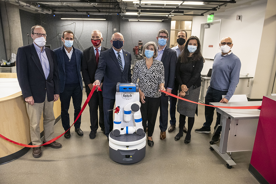 Leaders from CMU and JP Morgan pose with a robot that cut the ribbon at the space's opening.