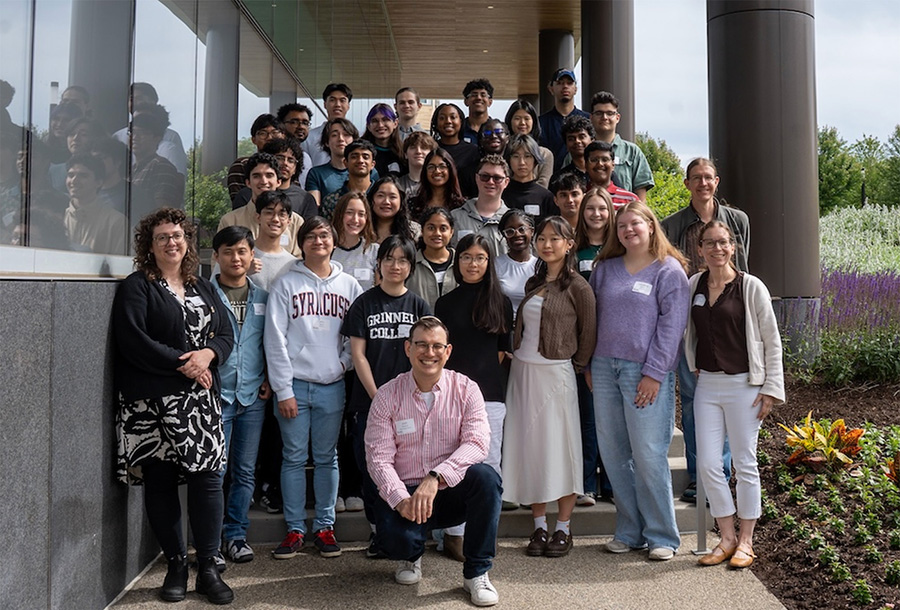 A diverse group of students and adults gathered outside a building in a formally posed shot.