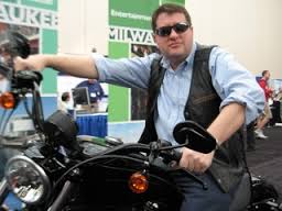 Tom on a motorcycle at a conference